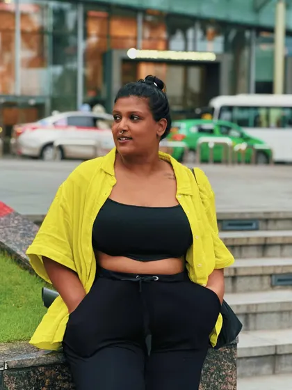 A casual look for walking around the city. I paired comfortable joggers with a black crop top and a bright yellow shirt for a pop of color. This is my go-to formula for a stylish and relaxed travel outfit.