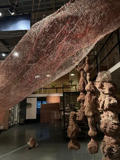 The 'Cu+Fibers' exhibition explores the incidental and the intentional in textile art. This piece, titled 'Colony', is a woven sculpture created from a play of natural fibers, where a broad intent gradually becomes a series of tangible, interconnected ideas.