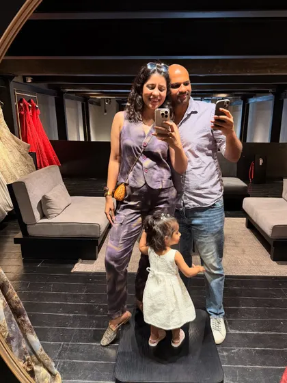 A family mirror selfie at the designer event. I'm wearing a tie-dye waistcoat and pants set, a comfortable yet stylish choice for the evening.