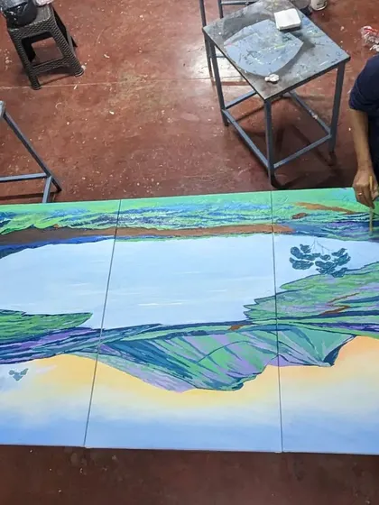 An overhead view of me working on the large canvases. This perspective shows the scale of the artwork and the focus required to paint the detailed reflections and foliage across the three panels.