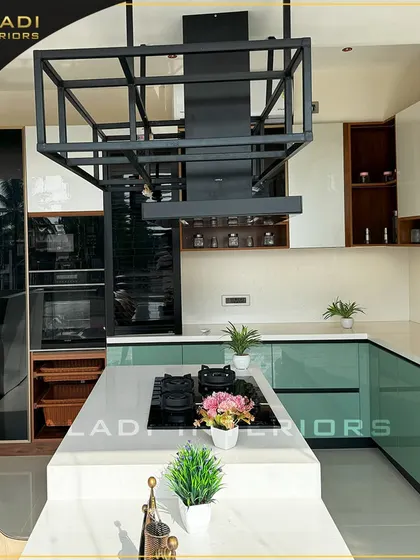 A wide shot of the modern green and white kitchen, showing the L-shaped layout, integrated appliances, and the open, airy feel of the space.