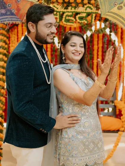 The bride proudly displays her intricate Mehendi design, her smile radiating pure joy. This shot perfectly captures the excitement of the pre-wedding rituals.