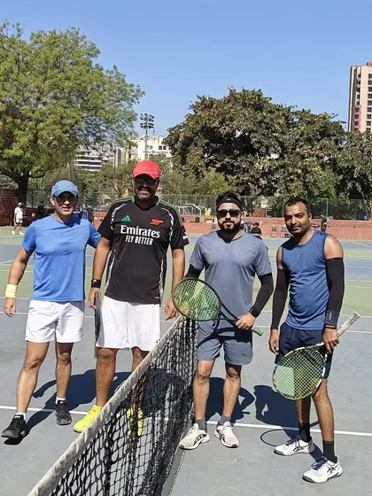 Players posing for a photo at the net during the Ad In Tennis Open at Modern School. Our events are a great way to meet fellow tennis enthusiasts.