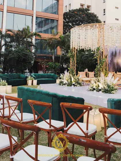 A closer look at the details of our minimalist forest-themed mandap. The structure is wrapped in lush greenery, with arrangements of white flowers and candles creating a romantic glow.