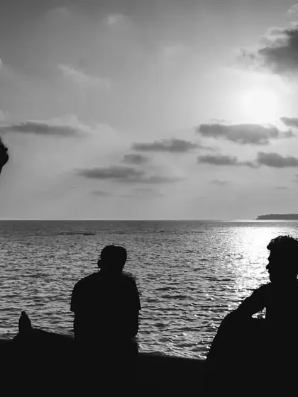 A black and white silhouette shot of people enjoying the sunset at Marine Drive. This more artistic, street-photography style allows me to capture the anonymous, shared moments that are so characteristic of Mumbai.