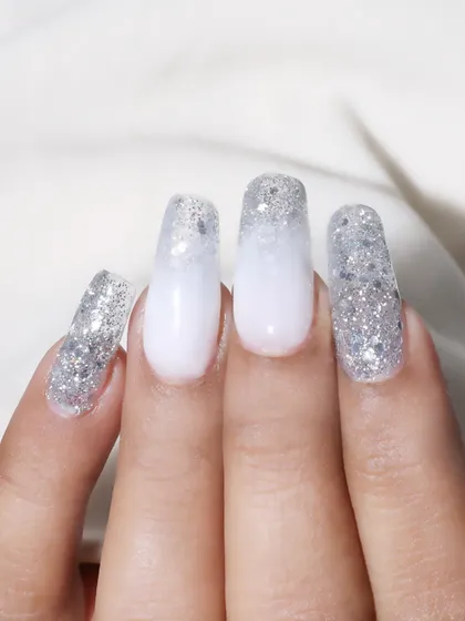 A beautiful example of glitter ombre nails. This design features a soft white base that fades into a dense silver glitter tip, perfect for a winter or bridal theme.