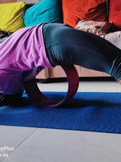 The yoga wheel is a fantastic prop for safely exploring deep backbends. Here, I am using it in my own practice to support my spine, which helps to open the entire front of the body and improve spinal flexibility.