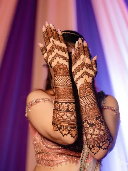 This design features beautiful arched patterns on the back of the hand, combined with intricate bands of geometric and floral work on the arms.