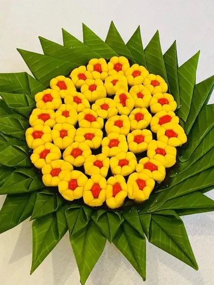 A beautiful arrangement of peda (milk-based sweet) on a plate made of folded banana leaves. This is a creative and traditional way to present sweets at your event.