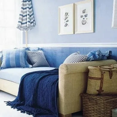 Inspired by coastal themes, this room uses a calming blue on the walls, paired with shades of navy and beige in the decor to create a relaxed, seaside vibe.