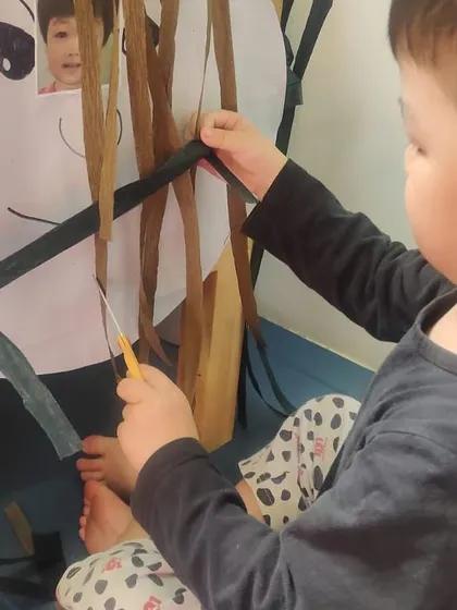Another young stylist works on his creation. Each station has a picture of the child, making the activity personal and even more engaging.