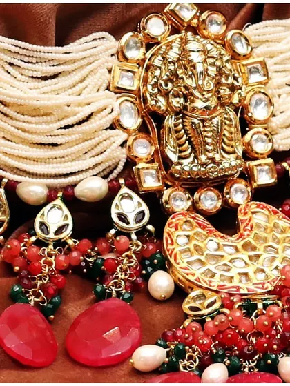 A close-up of our handcrafted jewellery, featuring a Ganesha motif piece with uncut diamonds and red stones, showcasing the divine artistry of our temple collection.