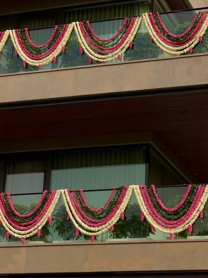 A closer view of the balcony decorations, showing the thick, lush garlands that add a touch of traditional elegance to the modern architecture.