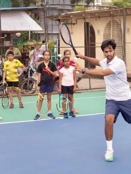 I believe in leading by example. Here, I demonstrate the correct forehand technique to a group of young players, showing them the body mechanics required to hit a clean, powerful shot.