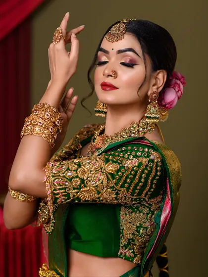 A side view of the bridal look, highlighting the intricate details of the blouse embroidery and jewelry.