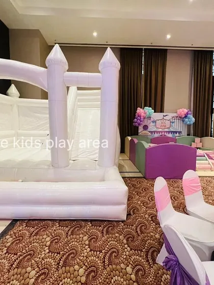 A clear shot of our 4-in-1 white bouncy castle, which includes a jumping area, climber, slide, and ball pit.