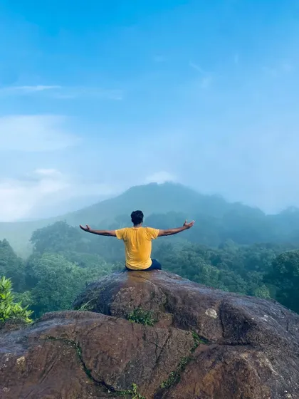 A moment of peace and meditation on a rock overlooking the misty forests of the Bandaje region.