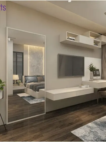 Another view of the minimalist bedroom in 'Konark Splendor', highlighting the floating TV unit and shelves, and the large mirror that enhances the sense of space.
