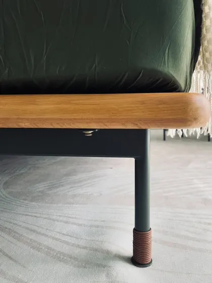 A close-up of the Tierra Bed's leg detail. The sandy army green steel legs are wrapped with a leather rope accent, a subtle yet distinctive touch that reflects the collection's desert-chic inspiration and our attention to every detail.