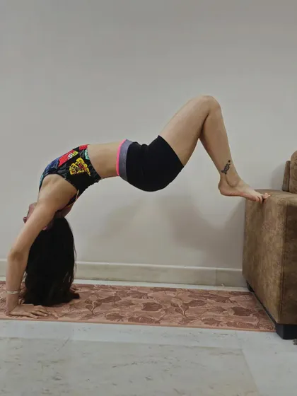 Chakrasana with feet raised on the sofa, balancing my chakras one asana at a time.