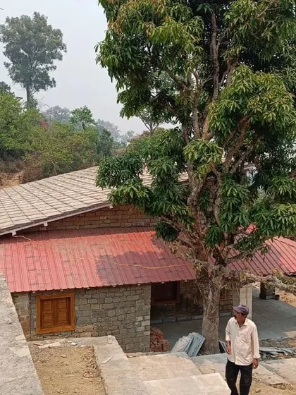 **Haat Market, Shyamlatal:** The building is nestled into the hillside, with a traditional sloped roof that responds to the local climate and architectural vernacular. The design respects the surrounding landscape.