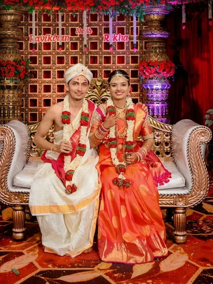 A classic, wide-angle shot of the couple on their wedding stage, capturing the grandeur of the setting.