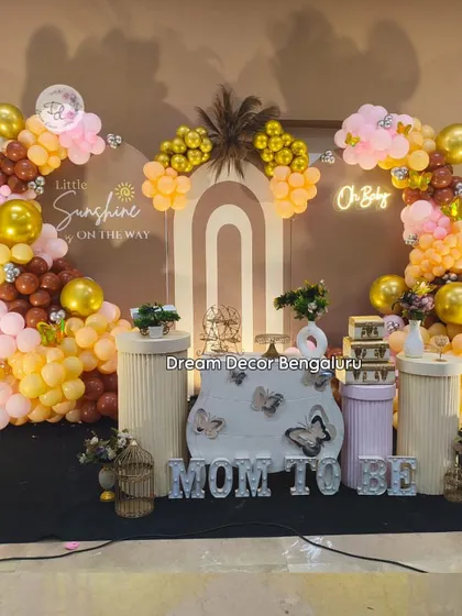 A modern take on a baby shower with a "Little Sunshine" theme. The earthy tones of the balloon decor, combined with pampas grass and a neon "Oh Baby" sign, create a chic and warm welcome.
