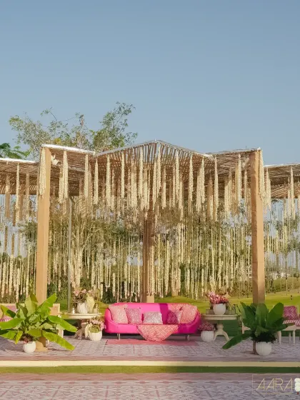 A wide shot of the serene bamboo pergola, draped in vibrant blooms. This setup was designed to be the perfect blend of nature and elegance for an outdoor Mehendi celebration.
