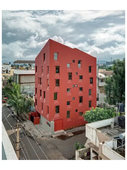 An elevated view showing the 'Stacked Student Housing' in its neighborhood context. The building's unique form is a result of its innovative sectional design.