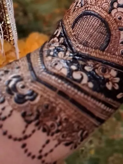 A macro shot of an armband with floral details and a delicate beaded chain design dropping down.