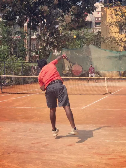 Two adult players compete in a singles match during the Men's Open Tour at Tennis360 Academy.