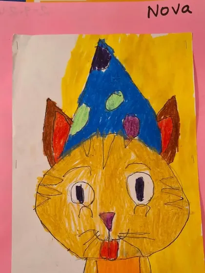 A finished portrait of a cat wearing a party hat, created by a young student. Notice the unique color choices and details that make this piece special and entirely his own.