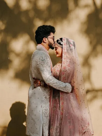 A romantic silhouette of the groom kissing his bride's forehead, a timeless and artistic wedding portrait.