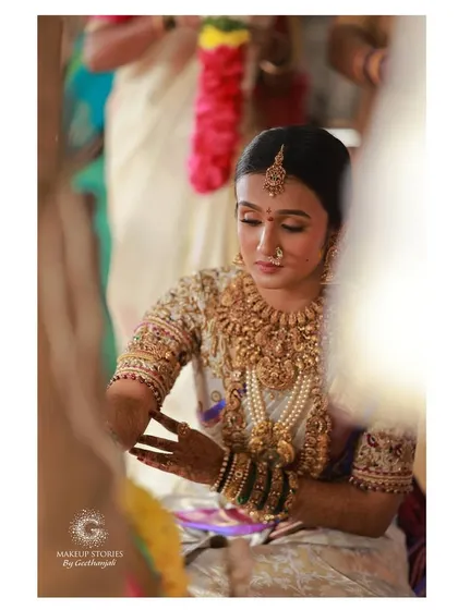 Vishnu Priya during her wedding ceremony. The makeup is subtle and elegant, allowing the richness of her temple jewelry and silk saree to take center stage.