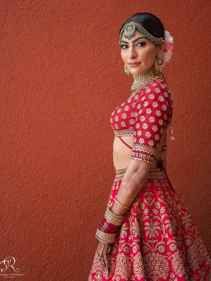 A classic and elegant side profile of the bride against a rich, textured wall.