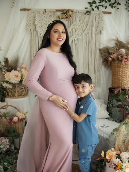 A proud big brother-to-be hugs his mom's belly. This portrait captures the beautiful bond between a mother and her son as they await the newest family member.