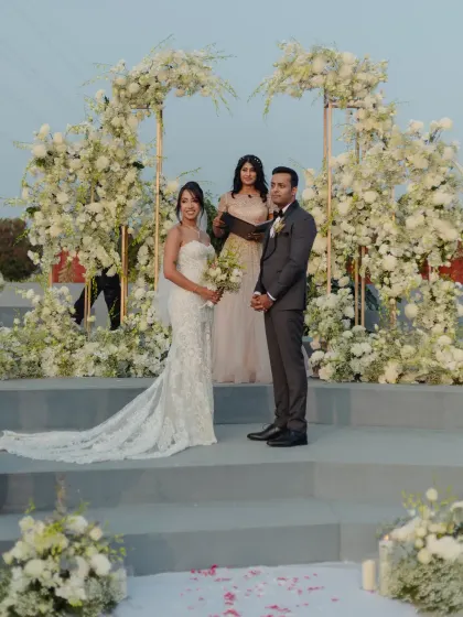 This modern Christian wedding ceremony featured a stunning asymmetrical floral arch, creating a chic and elegant backdrop for the couple to exchange their vows.