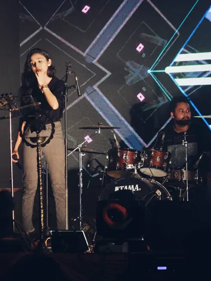 A candid moment during a soundcheck or performance. You can see my drummer in the background, holding the rhythm. It takes a team to make the magic happen.
