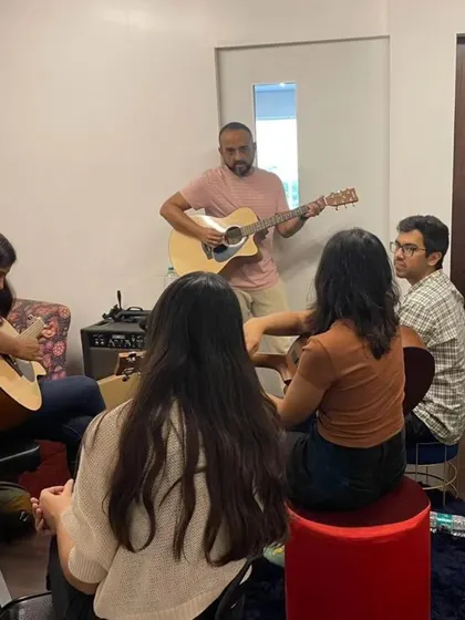 A guitar lesson in progress during our corporate workshop. Our instructors are patient and encouraging, making it easy for anyone to pick up an instrument for the first time.