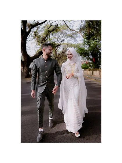 A classic wedding day portrait of a couple walking hand-in-hand. The bride's elegant white gown and the groom's tailored suit create a timeless look of love and commitment.
