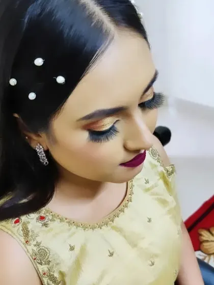 A side view of the party makeup, showing the dramatic winged liner and the placement of the pearl hair accessories.