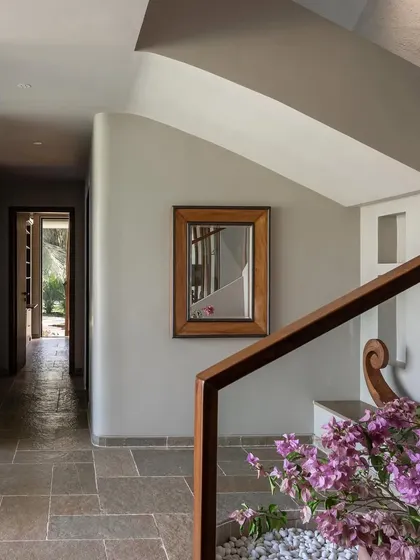 The hallway at Grove House, where the natural stone floor and simple wooden mirror create a rustic yet refined feel.