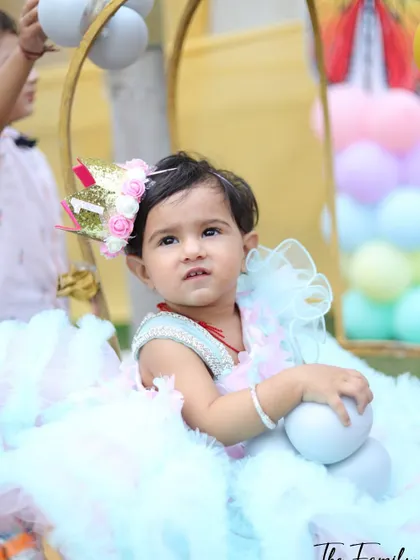This photo shows the birthday girl in her element, sitting in a decorative wicker chair surrounded by pastel balloons. It’s a great way to capture the theme and atmosphere of the party.