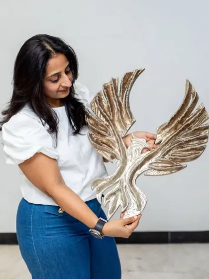 Holding "The Eternal Flight" sculpture. This piece feels both powerful and delicate in my hands, a balance I always strive for in my work.