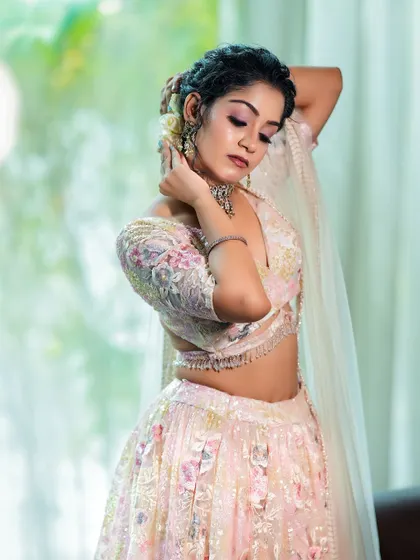 A graceful pose with hands behind the head, showcasing the sleeve design and the fit of the blouse.