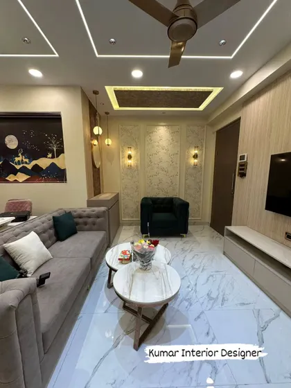 Another view of the Raymond Realty flat, highlighting the tufted sofa, marble-top coffee tables, and decorative wall panels.