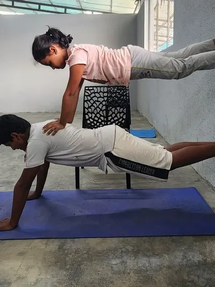 This creative partner plank uses a chair for elevation, adding a new level of difficulty and fun.
