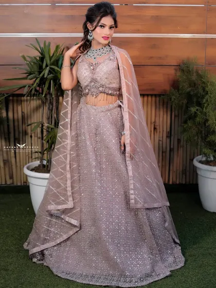 A confident pose showcasing the full silhouette of the modern lavender lehenga. The attached cape-style dupatta adds a touch of contemporary elegance.