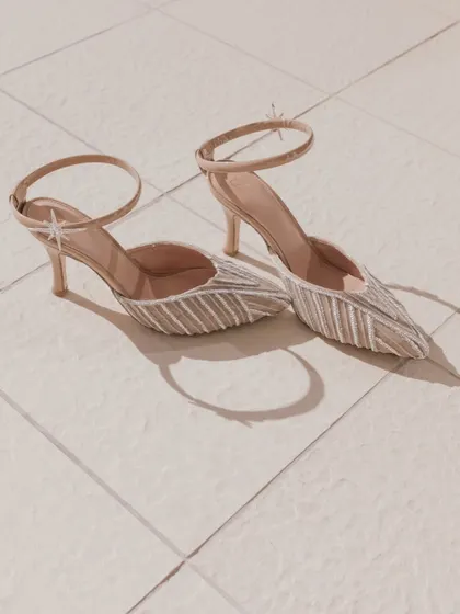 A simple, elegant shot of the bride's stylish pointed-toe heels, capturing a small but important detail of her wedding day look.