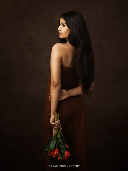The poetry of presence, captured in light. This pose, with flowers held behind her back, adds a touch of mystery and romance to the portrait.